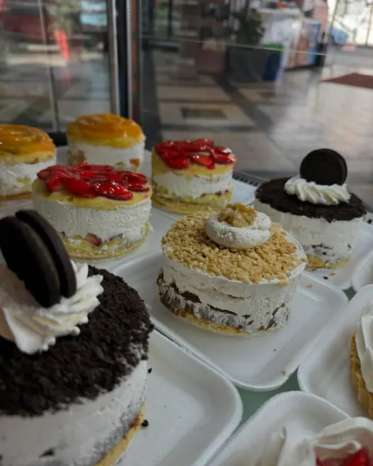 Vitrina con postres individuales de frutilla, durazno y Oreo