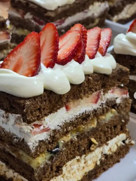 Porción de torta de chocolate con frutillas y crema